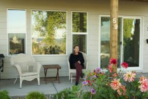 una mujer sentada en el porche delantero de una casa en AnnArthur Guest House, en Nanaimo