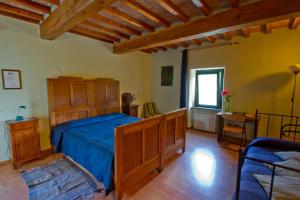 a bedroom with a bed, chair and a window at Agriturismo Foglie in Gubbio