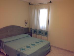 a bedroom with a bed and a dresser at Residence Marina Palace in Orosei