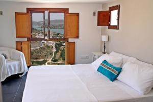 a bedroom with a white bed and a large window at Bed & Breakfast Casa El Sueño in Arcos de la Frontera