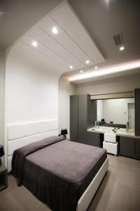 ナポリにあるGramsci Luxury Roomsのベッドルーム(大型ベッド1台付)、バスルームが備わります。