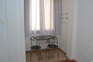 a table and two stools in front of a window at Studio Copacabana in Rio de Janeiro