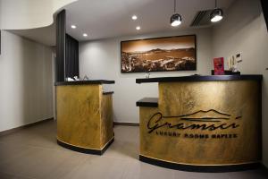 ナポリにあるGramsci Luxury Roomsの金の看板が壁に貼られたバー