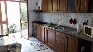 una cocina con armarios de madera y fregadero en Casa Giardino, en Spotorno