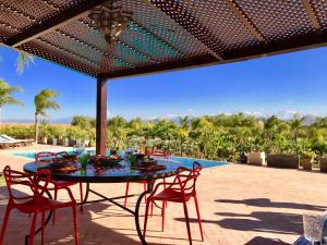 Villa Malika Marrakech في مراكش: فناء مع طاولة وكراسي ومسبح
