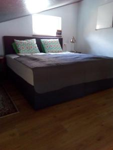 una camera da letto con un letto con una coperta blu e cuscini di Bootshaus a Eisenstadt