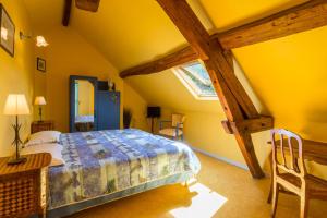 a bedroom with a bed and a table and a window at Chambres d'hôtes - Domaine Gigou in La Chartre-sur-le-Loir