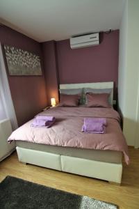 a bedroom with a large bed with purple pillows at Apartment Mavero-Free Private Parking in Zagreb
