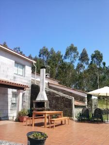 a patio with a wooden table and a fireplace at Casa Portomeiro in San Román