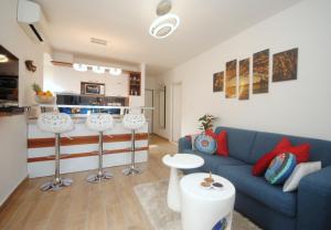 ein Wohnzimmer mit einem blauen Sofa und einer Küche in der Unterkunft Apartments Kogo in Split