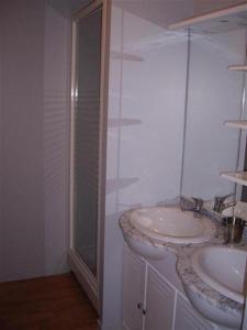 a white bathroom with a sink and a shower at La Terrasse des Oliviers in Mansigné