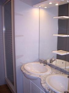 a white bathroom with two sinks and a shower at La Terrasse des Oliviers in Mansigné