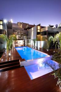 a swimming pool in front of a house at night at Dynasty Forest Sandown Self Catering Hotel in Johannesburg