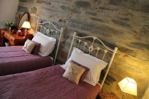 a hotel room with two beds and a stone wall at Yr Hen Fecws in Porthmadog