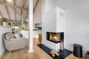 a living room with a fireplace and a chair at Alte Scheune am Focker Strom in Mursewiek