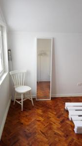 リスボンにあるWhite cosy apartmentの白い部屋(椅子、鏡付)