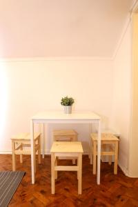 リスボンにあるWhite cosy apartmentの鉢植えのテーブルとベンチ