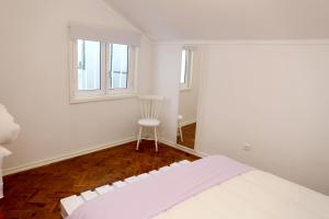 リスボンにあるWhite cosy apartmentの白い部屋(ベッド1台、椅子付)