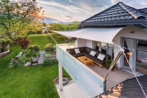 Cette chambre offre une vue sur une maison dotée d'une terrasse couverte avec un parasol blanc. dans l'établissement Bled Apartment Kirsch, à Bled