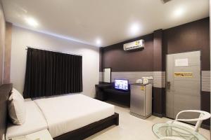 a bedroom with a bed and a tv in it at Seree Grand Resort in Hat Yai +29 photos