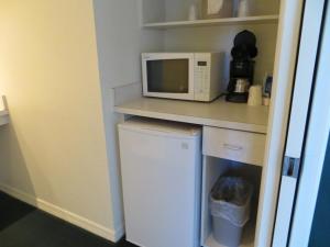 a small kitchen with a microwave and a small refrigerator at Central Motel - Inverness in Inverness