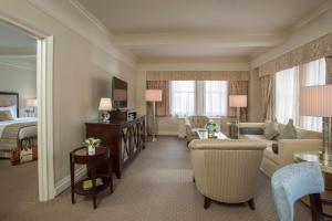 a hotel room with a king sized bed and a living room at Warwick New York in New York