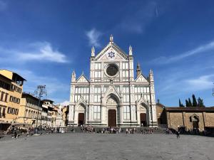 a large white church with a clock tower at Florence&Us Santa Croce in Florence