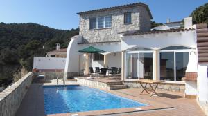 a house with a swimming pool in front of a house at Can Tapsy in Tossa de Mar