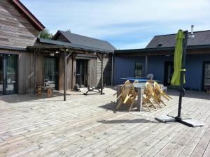 un patio con mesa, sillas y sombrilla en Le ptit Venton maison écologique pour particulier ou professionnel, en La Jaille-Yvon