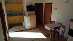 a small kitchen with yellow cabinets and a table at Apartments Stivic in Pinezici
