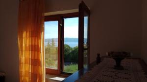 a room with a window with a view of the ocean at Apartments Stivic in Pinezici