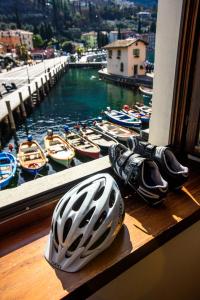 Un casco sentado en un alféizar junto a los barcos. en Hotel Benaco, en Nago-Torbole