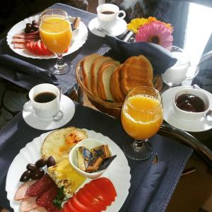 una mesa cubierta con platos de comida y vasos de zumo de naranja en Elit Hotel, en Sofía