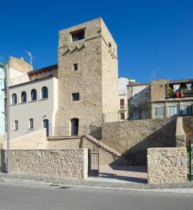 a building with a stone wall next to a street at Torre della Loggia - Dimora Storica - Ortona in Ortona