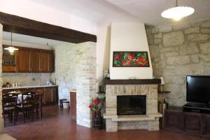 a living room with a stone fireplace and a tv at Casa immersa nel verde in Torricella Peligna