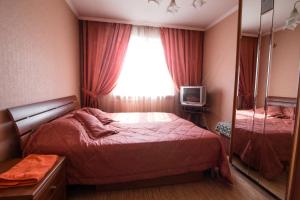 a small bedroom with a bed and a window at Кузнецктроевский in Novokuznetsk