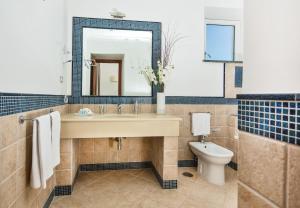 a bathroom with a sink and a toilet and a mirror at Hotel Villa Ceselle in Anacapri