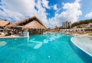 - une piscine d'eau bleue dans un complexe dans l'établissement Sandals Grenada All Inclusive - Couples Only, à Bamboo