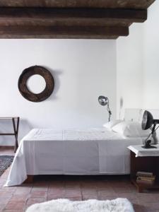 Locanda San Fantino في مدينة سان غيوفاني أبيرو: غرفة نوم بيضاء مع سرير ومرآة على الحائط