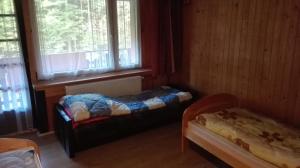 a small room with a bed and a window at Agroturystyka pod Pstragiem in Zawoja