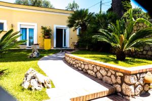 a house with a stone retaining wall and a walkway at Hotel Villa Ceselle in Anacapri