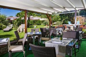 a restaurant with tables and chairs on a lawn at Hotel Villa Ceselle in Anacapri