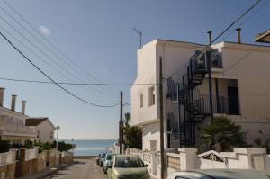 una calle con coches estacionados en el lateral de un edificio en Apartamentos Capri-Playa, en Sant Carles de la Ràpita