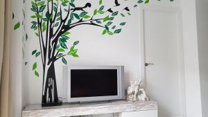 a tv in a room with a tree with birds on it at Apartamento Jardín de Ayora in Valencia
