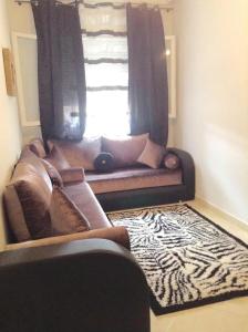 - un canapé dans le salon doté d'une fenêtre dans l'établissement Etablissement moderne, à Safi