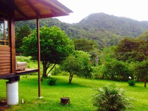 Lemon House Monteverde في مونتيفيردي كوستاريكا: منزل مطل على حقل أخضر وجبال