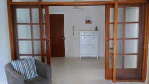 sala de estar con silla y puertas correderas de cristal en Modern City Center Apt, en Lárnaca 4 fotos más