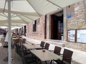 une rangée de tables et de chaises avec des parasols blancs dans l'établissement Hostal Meson la Cadena, à Trujillo