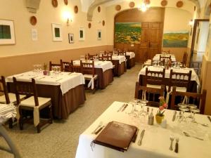 a dining room with tables and chairs with white tablecloths at Hostal Meson la Cadena in Trujillo
