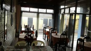 een restaurant met tafels en stoelen en grote ramen bij Hotel Capri in Guatemala